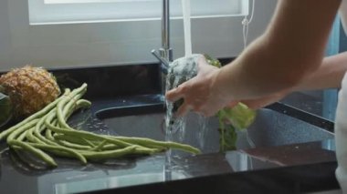 Yakın çekim kadının elleri brokoli yavaş iç mutfak, yıkama