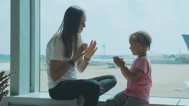 青年妈妈和小可爱的女儿在机场慢动作乐趣. — 图库视频影像