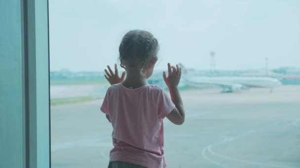 Küçük kız çocuk pencereden uçağa, arka görüntü görünüyor.. — Stok video