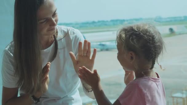 Мать и маленькая симпатичная дочь веселятся в аэропорту в замедленном режиме . — стоковое видео