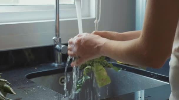 Close-up mulheres mãos lavar brócolis na cozinha doméstica em câmera lenta — Vídeo de Stock
