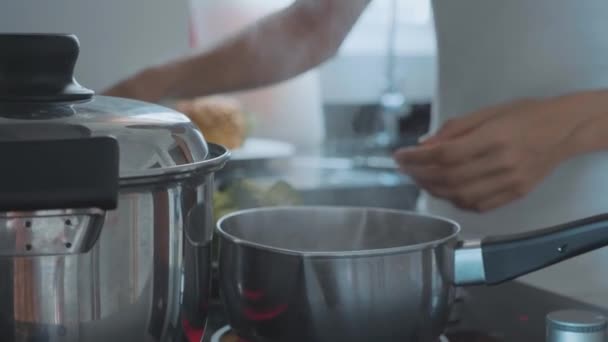 Рука з ложкою, що перемішує киплячу сочевицю для овочевого супу, крупним планом . — стокове відео