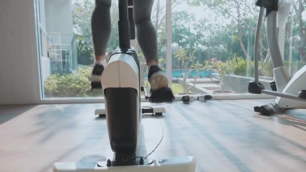 Κοντινό πλάνο γυναικεία Καβάλα σε σταθμευμένο ποδήλατο στο γυμναστήριο σε αργή κίνηση — Αρχείο Βίντεο