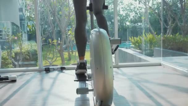 Mujer joven deportiva haciendo ejercicio en la máquina de paso en el gimnasio en cámara lenta . — Vídeos de Stock