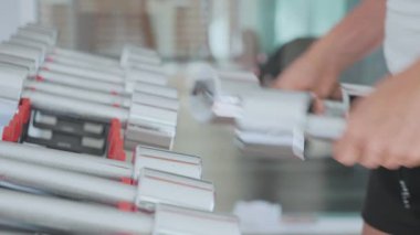 Genç kadının dumbbell geri koyarak iki ağırlık raf, yakın çekim eller.