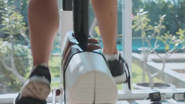 Gros plan jambes féminines en vélo stationnaire au gymnase au ralenti — Video