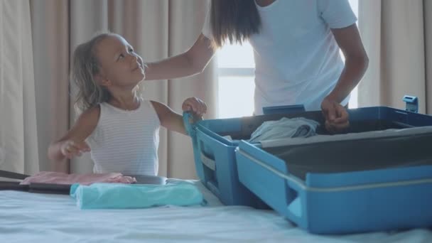 Joven con hija pequeña recogiendo una maleta juntos . — Vídeos de Stock