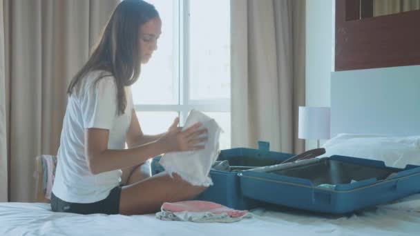 Young woman is collecting a suitcase. The traveler preparing for journey. — Stock Video