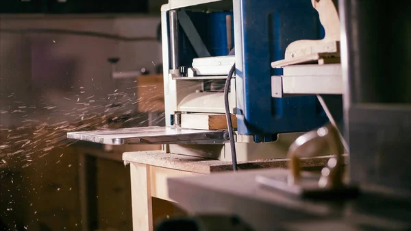Dolap planlama makinesi ahşap atölyesinde talaşla çalışıyor. 