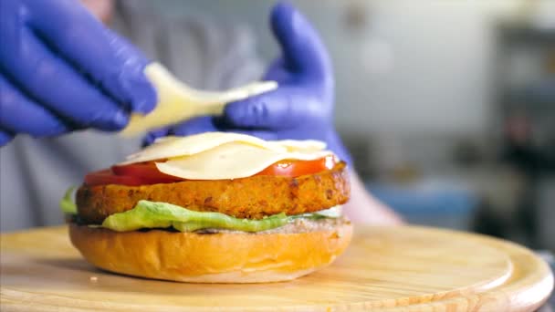 Närbild skott av kockar händer förbereda en läcker hamburgare med ost. — Stockvideo