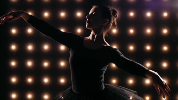 Silhouet van ballerina in zwarte jurk danst ballet in de donkere studio. — Stockvideo