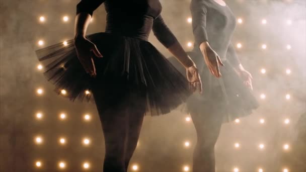 Силуэт двух балерин в черной пачке танцует балет в темной студии . — стоковое видео