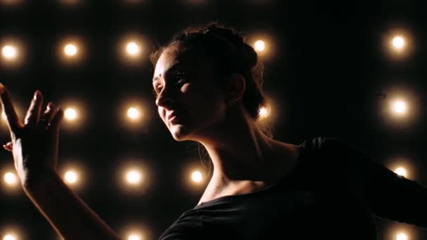 La silhouette della ballerina in abito nero sta ballando balletto nello studio buio . — Video Stock