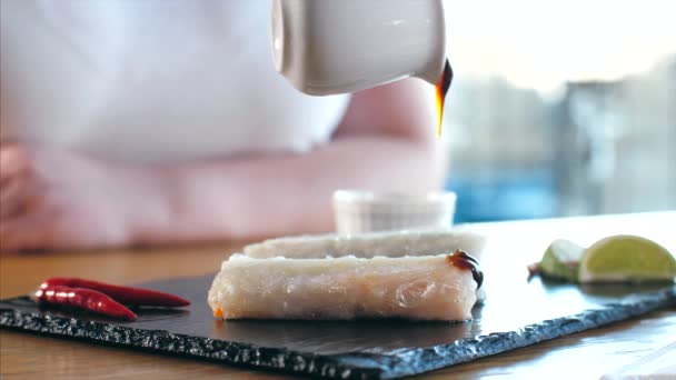 Pouring a sauce on serving original asian spring rolls, close-up. — 图库视频影像