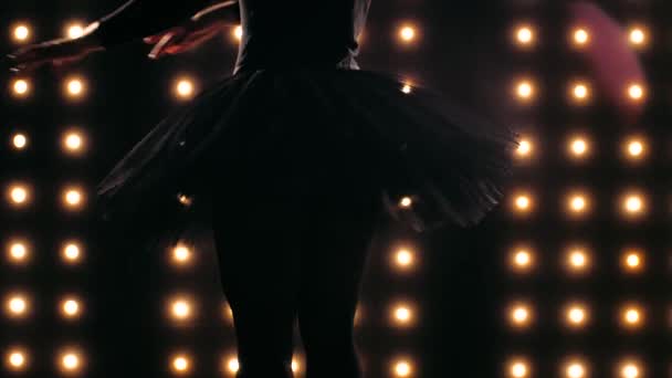 Силует балерини в чорному навчанні танцює балет в темній студії . — стокове відео