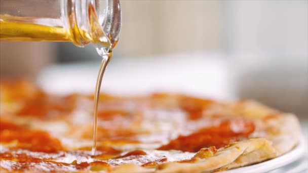 Gießt Öl in Nahaufnahme auf die Pizza — Stockvideo
