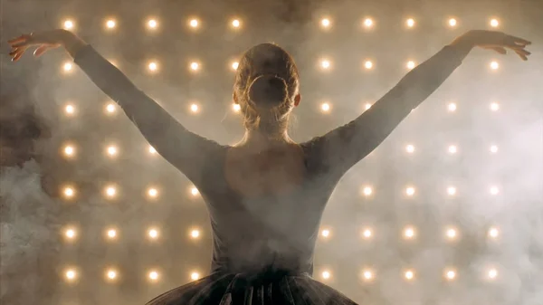Silhouette einer Ballerina in schwarzem Tutu tanzt Ballett im dunklen Studio. — Stockfoto