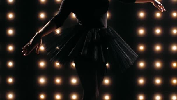 Силует балерини в чорній сукні танцює балет у темній студії . — стокове відео