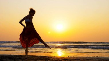 gün batımında sahilde dans genç kız silüeti
