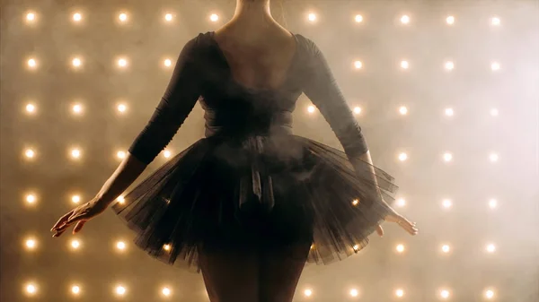 Sylwetka baleriny w czarnym tutu tańczy balet w ciemnym studio. — Zdjęcie stockowe