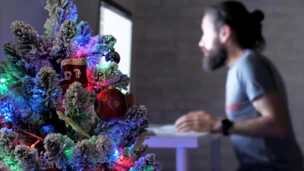 L'uomo barbuto sta lavorando sul computer desktop al buio durante le vacanze di Natale . — Video Stock