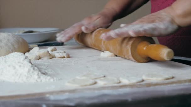 年长女性的亲密手在家里厨房里为饺子卷着面团 — 图库视频影像