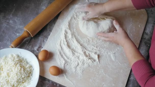Крупным планом руки пожилой женщины смешивают тесто на домашней кухне, над видом — стоковое видео