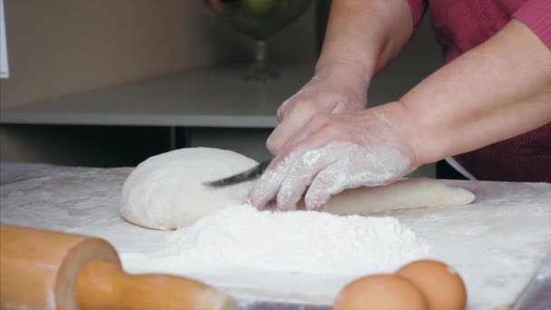 Le mani di primo piano di femmina più anziana sono tagli una pasta in pezzi a cucina familiare . — Video Stock