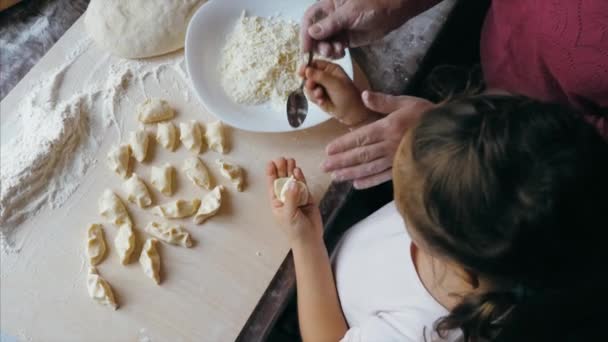 Бабушка с внучкой готовит пельмени с сыром на домашней кухне. — стоковое видео