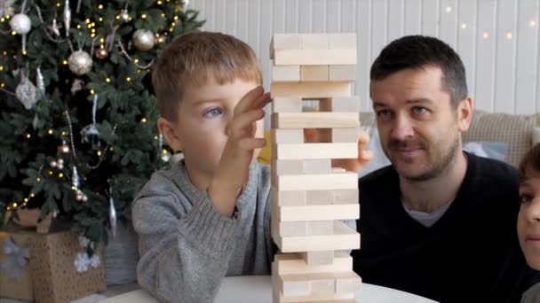 La familia está jugando en la torre de madera en casa — Vídeo de stock