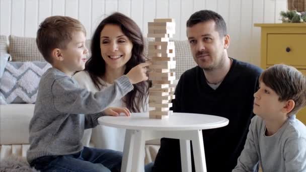 La familia está jugando en la torre de madera en casa — Vídeo de stock