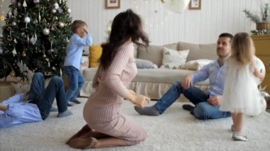 Large family with three children is having fun at home in Christmas eve