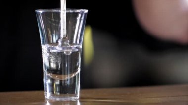 Barman is making alcohol cocktail with three layers