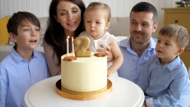 Cute little child girl is blowing the candles on birthday cake — ストック動画