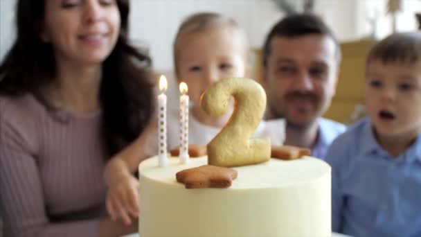 Linda niña está soplando las velas en el pastel de cumpleaños — Vídeo de stock