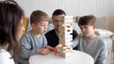 Family is playing in wooden tower at home