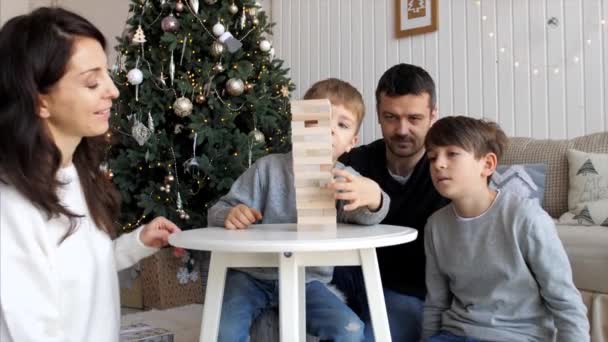 La familia está jugando en la torre de madera en casa — Vídeo de stock