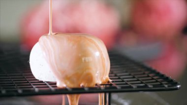 Close-up of a pouring glazing over heart shape dessert in slow motion.