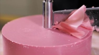 Confectioner is making a petals from pink chocolate on round cutter