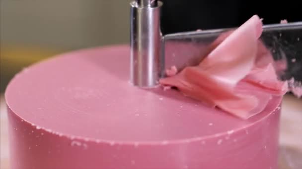 Кондитер делает лепестки из розового шоколада на круглой резке — стоковое видео