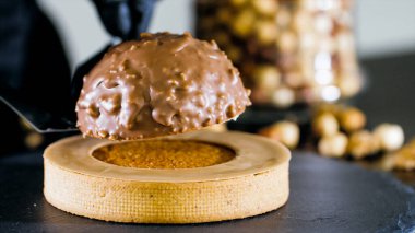 Close-up of chef is making dessert with milk chocolate and nuts