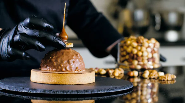 Крупный план шеф-повара делает десерт с молочным шоколадом и орехами — стоковое фото