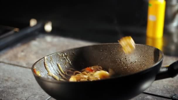 Chef cocinando fideos en sartén wok en la cocina comercial — Vídeos de Stock