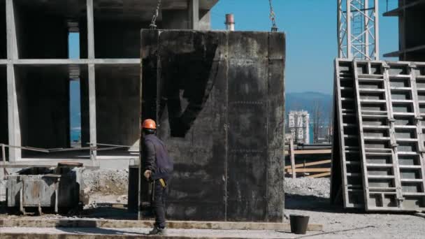 Builder förbereder en panel för installation på en byggarbetsplats. — Stockvideo