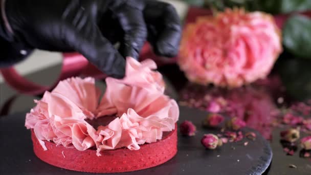A cukrász desszertet csinál rózsaszirmokkal rózsaszín csokoládéból. — Stock videók