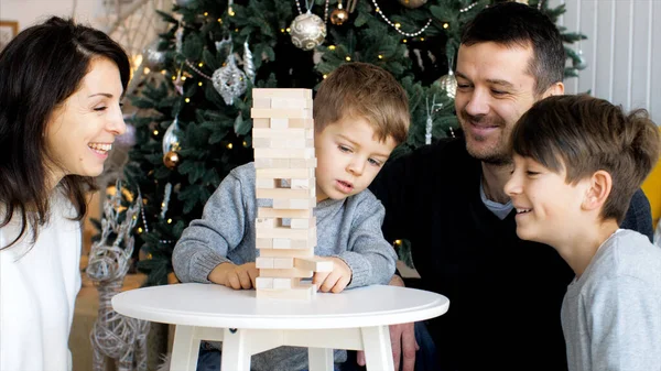 Οικογένεια παίζει σε ξύλινο πύργο στο σπίτι — Φωτογραφία Αρχείου