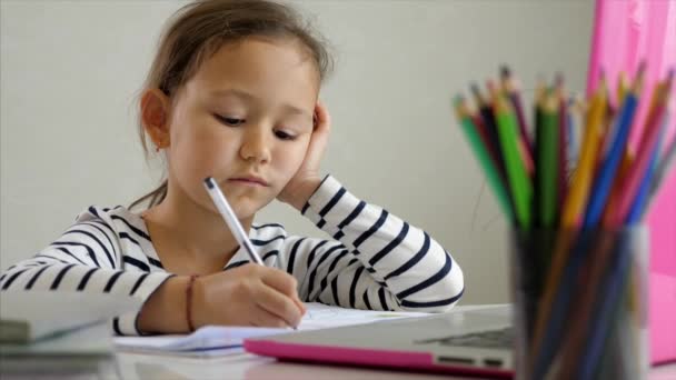 Маленькая девочка учится дома онлайн — стоковое видео