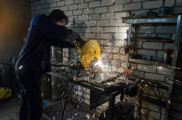 Arbeiter hält das Metallrohr in der Hand, um es an der Maschine zu schneiden. vor dem Hintergrund weißer Ziegel — Stockfoto