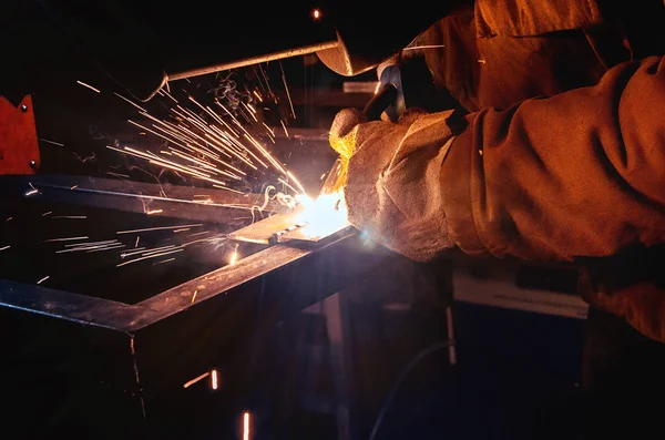 Schweißer in Schutzmaske in einer dunklen Werkstatt, bereit, an Metall zu arbeiten — Stockfoto