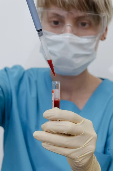 Laboratuvar asistanı kan örneğini analiz ediyor.